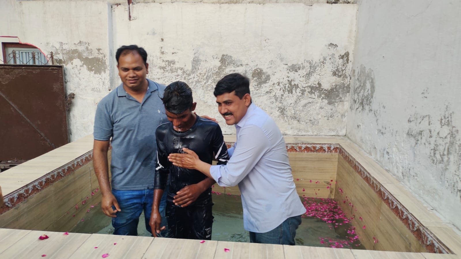Ministry leaders helping a candidate during baptism