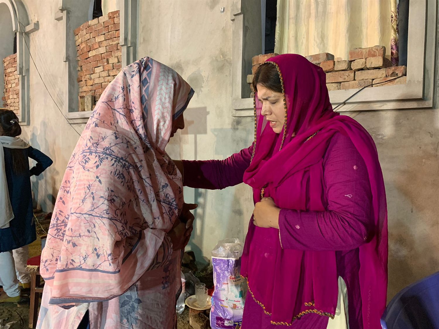 Two women praying together during ministry outreach